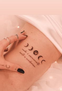 a woman's stomach with her hand on the side of her belly and three phases of the moon