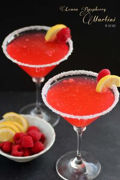 two glasses filled with raspberry vodka and garnished with lemon wedges