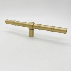 a brass colored metal handle on a white background