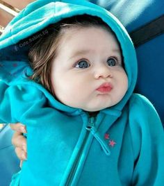 a small child wearing a blue hooded jacket