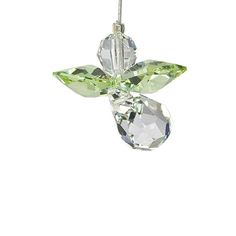 an ornament with green crystals hanging from it's side on a white background