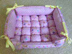 a pink and yellow box filled with lots of pillows