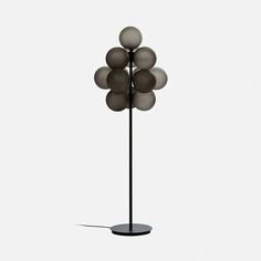 a lamp that is on top of a metal pole with five balls hanging from it