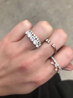 a woman's hand with two rings on her fingers and one ring in the middle