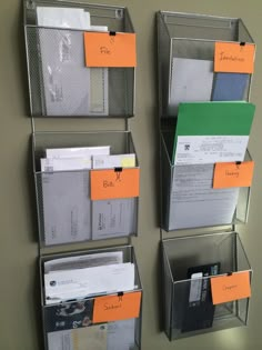 three metal bins holding files and folders with orange tags attached to the sides