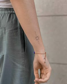 a person with a small tattoo on their left arm holding the hand of another person