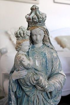 a statue of the virgin mary holding a baby jesus in her arms and wearing a crown