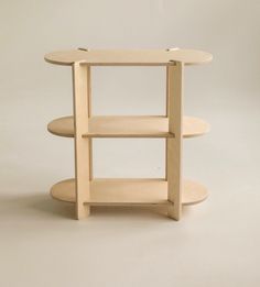 a three tiered wooden shelf with two circular shelves on the bottom and one round shelf at the top