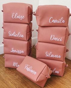 four pink bags with names on them sitting on the floor