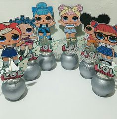 the lol dolls are standing on top of each other in front of some silver balls