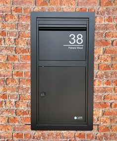 a black mailbox mounted to a brick wall with the number eighty eight on it