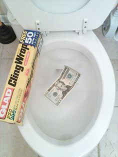 a roll of cash sitting on top of a toilet