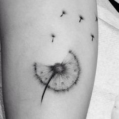 a dandelion tattoo on the thigh