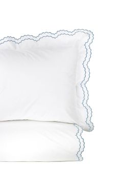 two white pillows with blue scalloped edges