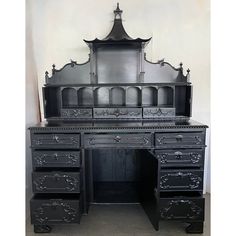 an antique black desk with drawers and a mirror