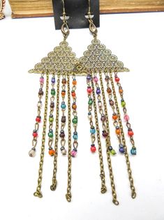 7 3/4" X 2 1/4" Antiqued Gold Tone Stamped Metal, Rhinestones, And Glass .3 Ounces Each - Very Lightweight! Brand New On Card Vintage Multicolor Beaded Dangle Earrings, Multicolor Metal Dangle Chandelier Earrings, Handmade Multicolor Metal Chandelier Earrings, Handmade Metal Multicolor Chandelier Earrings, Festival Beaded Chain Earrings, Multicolor Beaded Chain Earrings For Parties, Multicolor Beaded Chandelier Earrings For Festive Occasions, Festive Multicolor Beaded Chandelier Earrings, Handmade Multicolor Metal Beaded Earrings