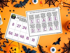 a table topped with lots of halloween decorations and paper cut out to spell the word scare