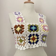 a crocheted top on a mannequin with flowers in the front and back