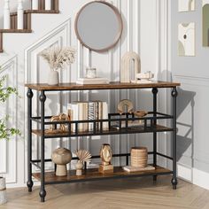 a shelf with books, vases and other items on it in front of a staircase