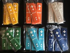 six different colored plastic pegs with white polka dots on them in cellophane bags