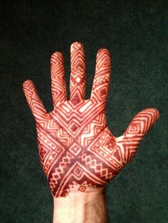 a man's hand with an intricate pattern on it, showing the fingers and palm