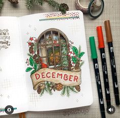 an open notebook with the words december written on it next to some markers and pencils