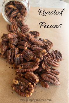 roasted pecans in a glass jar on top of a piece of parchment paper with the words, roasted pecans