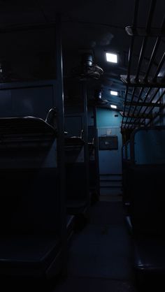 the inside of a train car at night with lights on and no people in it