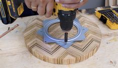 a person using a drill to attach a piece of wood on top of a table