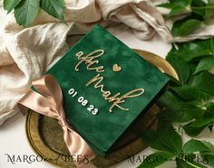 a green graduation cap with gold writing on it sitting on top of a golden plate