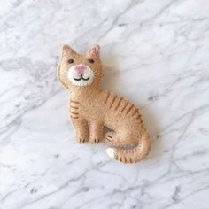 a cat brooch sitting on top of a white marble counter