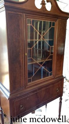 an old wooden china cabinet with glass doors