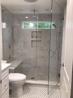 a white toilet sitting next to a walk in shower