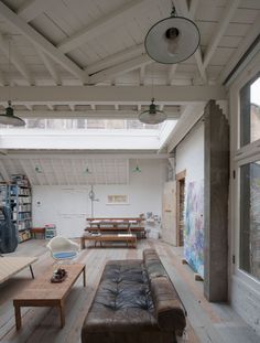 a living room filled with furniture and a skylight over the top of it's roof