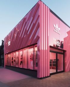 a pink building that is next to a sidewalk