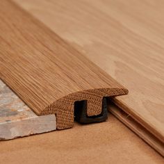 a close up view of a wooden floor with the corner cut out to show woodgrain