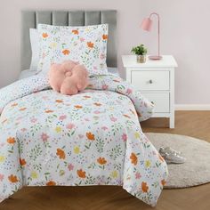 a bedroom with a bed, nightstand and pink pillow on top of the headboard