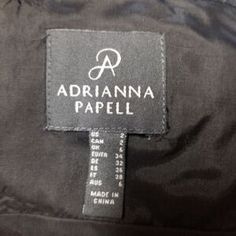 a label on a black jacket that says, adrianna papeli in china