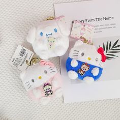 two hello kitty keychains are sitting next to each other on a white surface