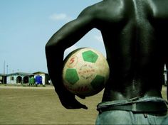 a man with his back to the camera holding a soccer ball