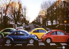 four different colored cars are parked on the street