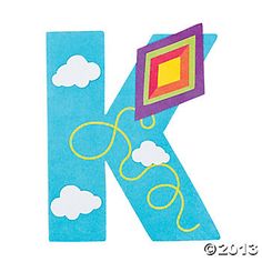 the letter k is made up of paper with clouds and a kite on it's side