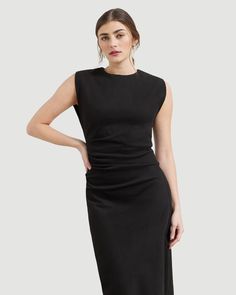 a woman is wearing a black dress with an asymmetrically shaped neckline