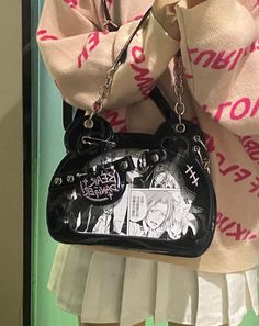 a woman holding onto a black purse with anime characters on it