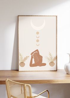 a white vase sitting on top of a wooden table next to a framed art print