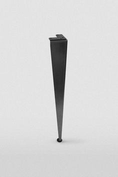 a tall black object is standing in the middle of an empty room with white walls