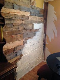 a room that has some wood on the wall and a table in front of it