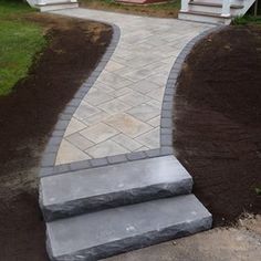 a stone walkway with steps leading up to the house