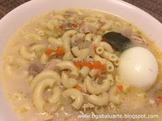 a white plate topped with pasta and an egg