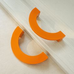 an orange object sitting on top of a wooden floor next to a white wall,